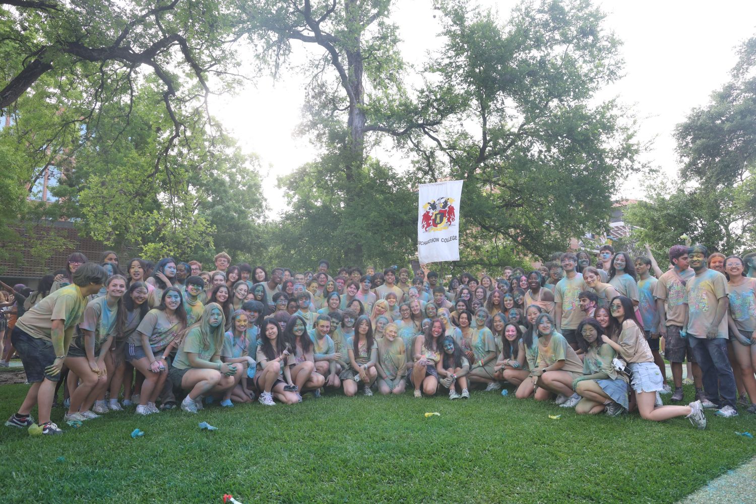 the whole sid richardson college crowd covered in powder paint, gathered under the college banner at beer bike