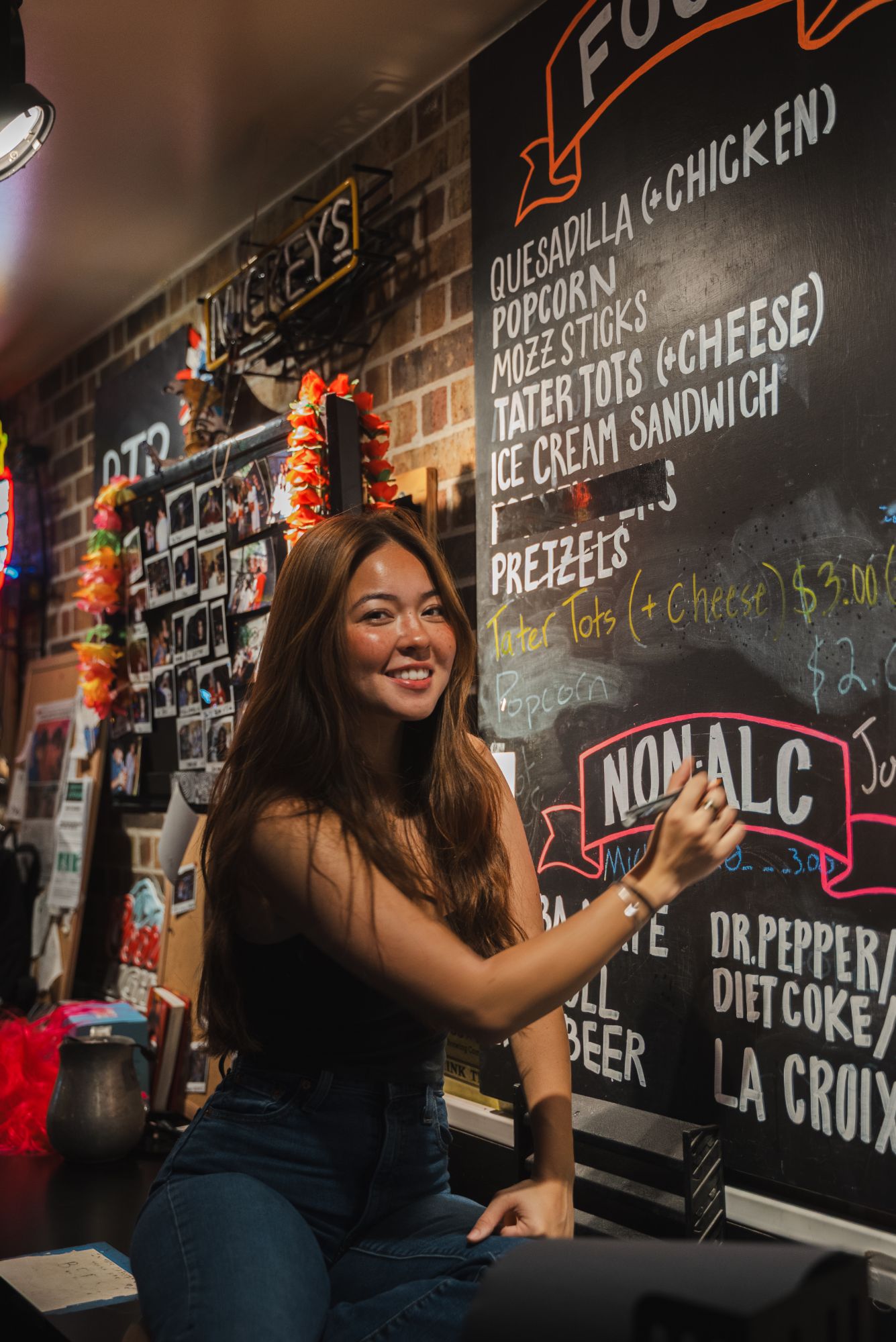 hand-lettered pub food and drink menu on a chalkboard behind the bar